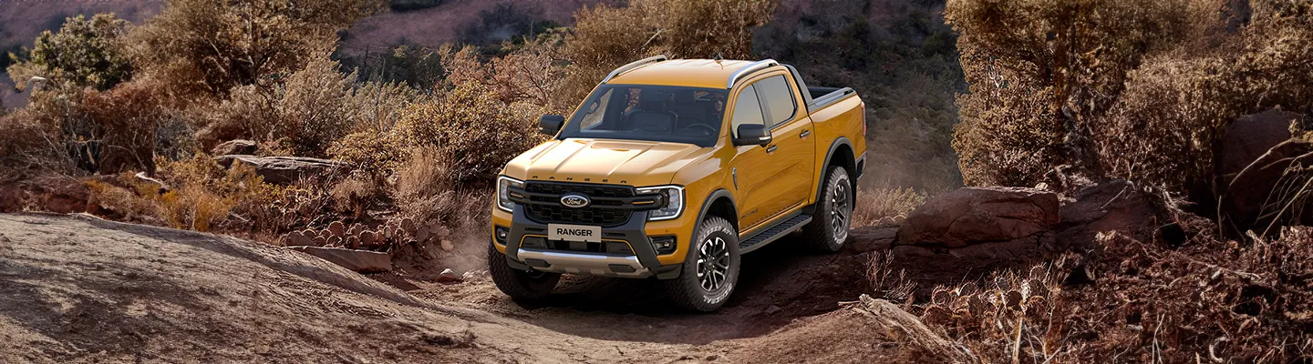 Kayalık arazi parkurunda ilerleyen sarı yeni Ford Ranger